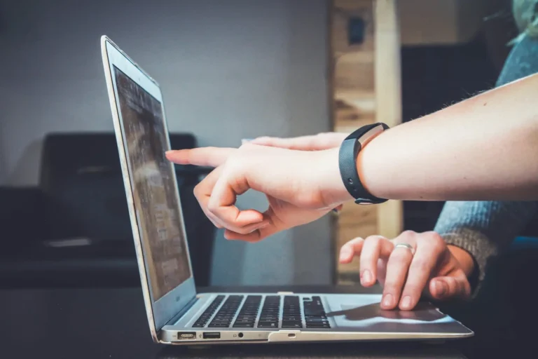 Quelqu'un qui montre du doigt un écran de pc portable